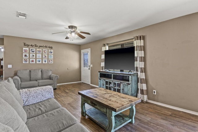 living area featuring visible vents, baseboards, ceiling fan, and wood finished floors