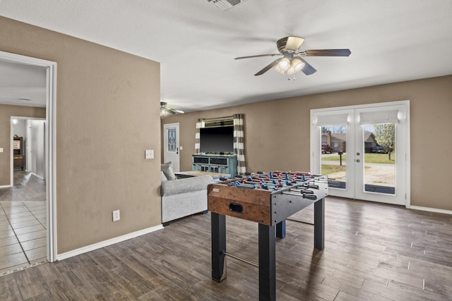 recreation room featuring french doors, baseboards, ceiling fan, and wood finished floors