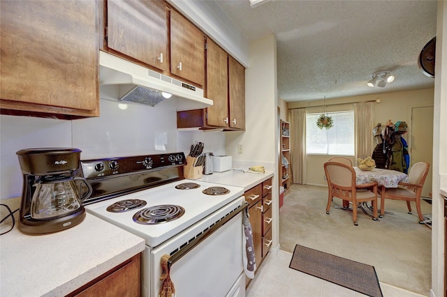 4405 Tophill Ln, Irving, TX 75038 - kitchen featuring light countertops, brown cabinetry, under cabinet range hood, and electric range