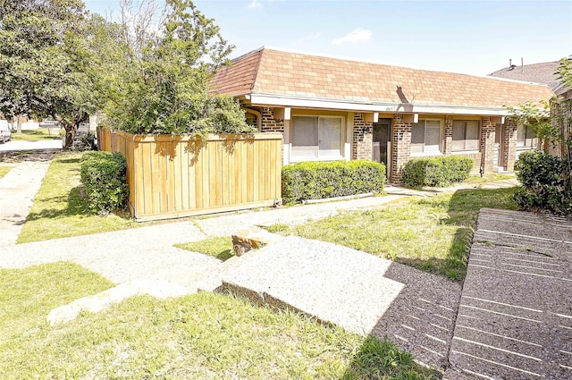 4405 Tophill Ln, Irving, TX 75038 - view of front facade with fence, mansard roof, roof with shingles, and brick siding
