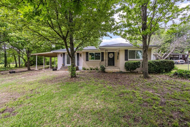 single story home with brick siding, entry steps, a front yard, and a carport