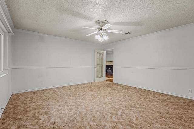 carpeted spare room featuring crown molding, a ceiling fan, and a textured ceiling