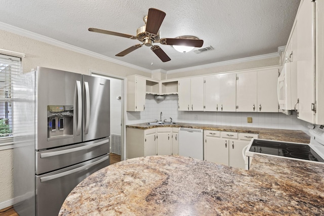 kitchen featuring ornamental molding, a healthy amount of sunlight, white appliances, and tasteful backsplash