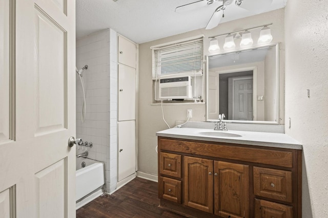 bathroom with ceiling fan, wood finished floors, vanity, cooling unit, and bathing tub / shower combination