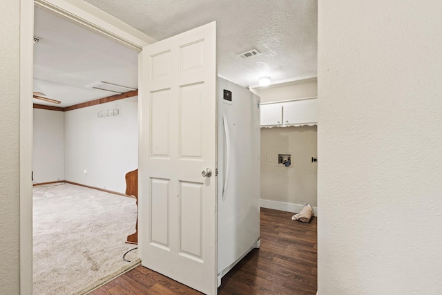 hall featuring dark wood-style flooring, baseboards, visible vents, and a textured ceiling