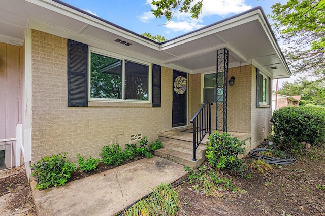 view of exterior entry with brick siding