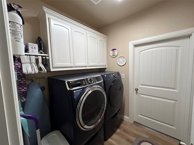 540 Islet Dr, Runaway Bay, TX 76426 - laundry area with washer and dryer, light wood finished floors, and cabinet space