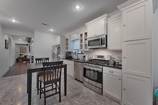 5513 Willis Ave, Dallas, TX 75206 - kitchen featuring stainless steel appliances, crown molding, dark countertops, a sink, and tasteful backsplash