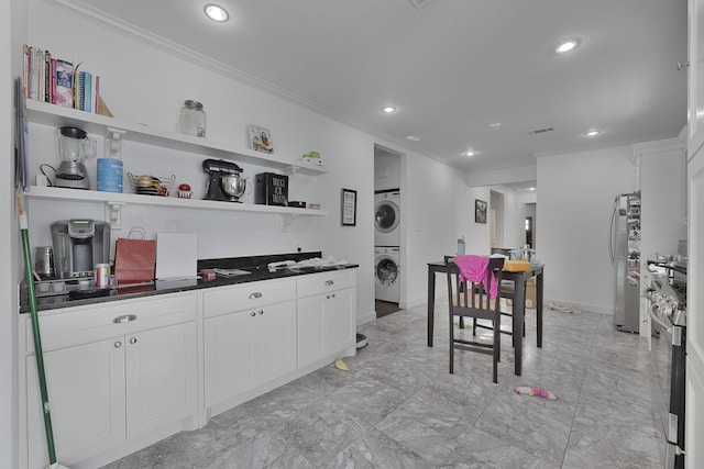 kitchen featuring open shelves, stacked washing maching and dryer, freestanding refrigerator, recessed lighting, and ornamental molding