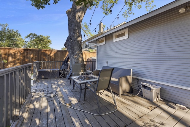 wooden terrace featuring fence, cooling unit, and an outdoor fire pit