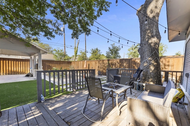 deck featuring a fenced backyard, a yard, and an outdoor fire pit