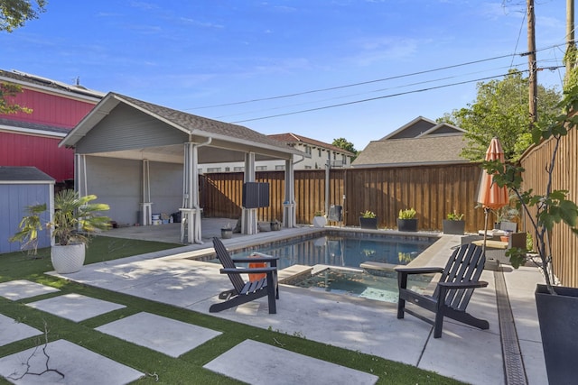 view of pool featuring an outbuilding, a patio area, a fenced in pool, a fenced backyard, and a storage unit