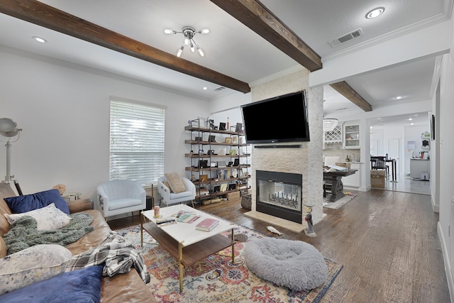living room featuring visible vents, a fireplace, wood finished floors, beamed ceiling, and recessed lighting