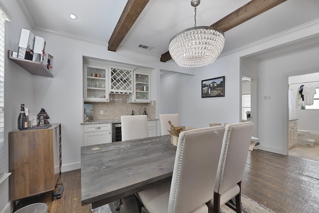 dining space with visible vents, beamed ceiling, beverage cooler, a chandelier, and bar area
