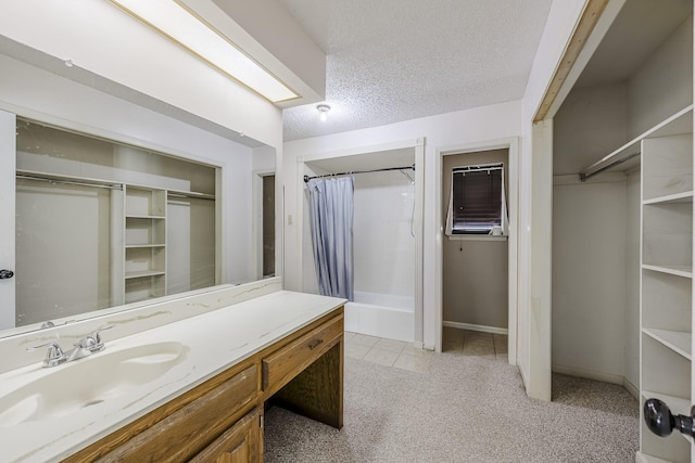 703 Athenia Way, Duncanville, TX 75137 - bathroom with vanity, shower / bath combo, tile patterned floors, a textured ceiling, and a walk in closet