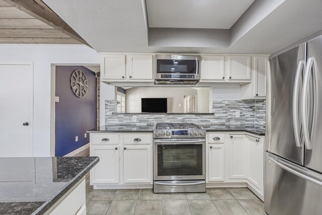 703 Athenia Way, Duncanville, TX 75137 - kitchen featuring appliances with stainless steel finishes, white cabinetry, backsplash, and dark stone counters
