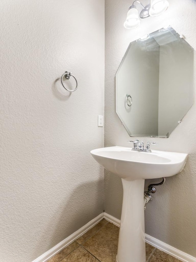 bathroom with baseboards and tile patterned floors