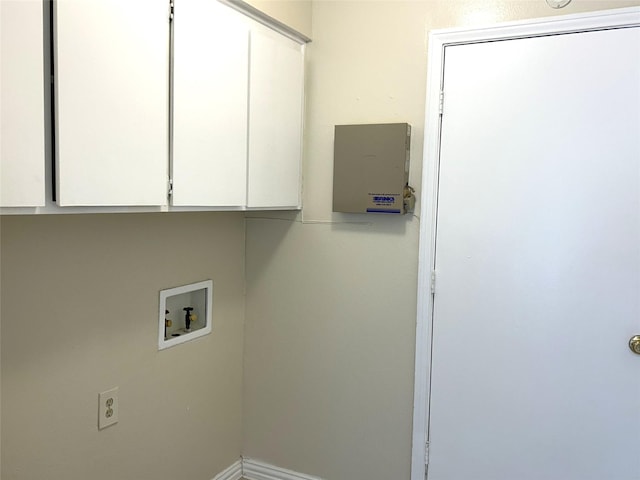 clothes washing area featuring baseboards, cabinet space, and washer hookup