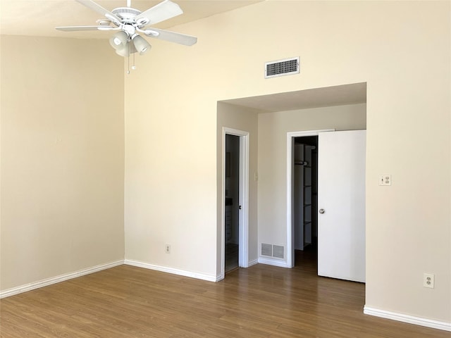 spare room with baseboards, ceiling fan, wood finished floors, and visible vents
