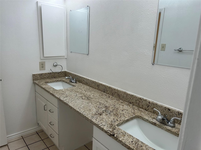 full bathroom featuring double vanity, a sink, and tile patterned floors