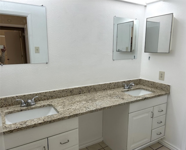 bathroom with tile patterned flooring, a sink, and double vanity
