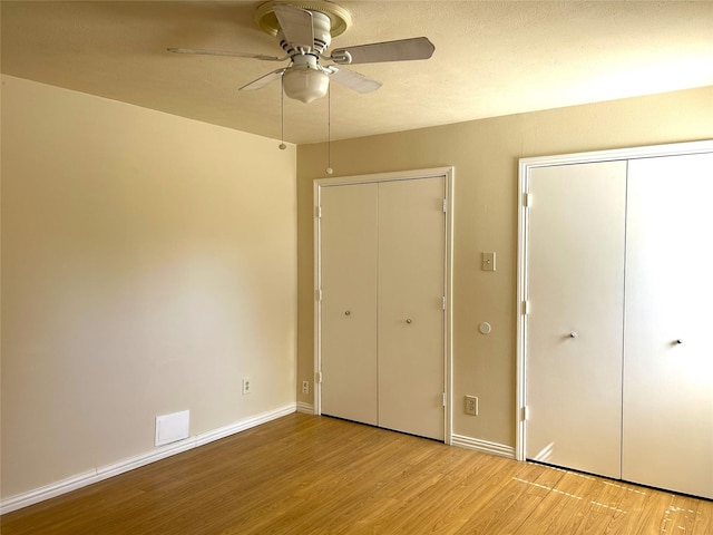 unfurnished bedroom featuring baseboards, ceiling fan, and light wood finished floors