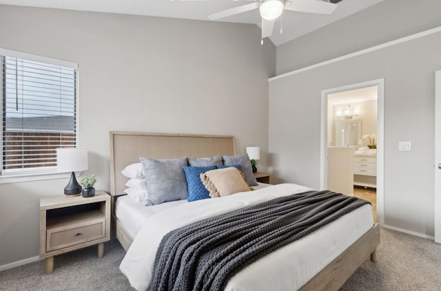 bedroom with lofted ceiling, baseboards, connected bathroom, and carpet