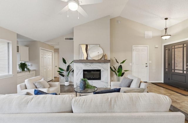 kitchen featuring vaulted ceiling, white cabinets, light stone countertops, appliances with stainless steel finishes, and a kitchen island