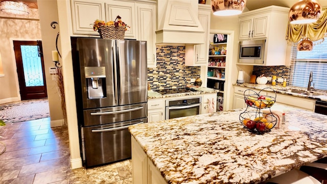 4010 Knightsbridge Ln, Midlothian, TX 76065 - kitchen with decorative backsplash, appliances with stainless steel finishes, a sink, light stone counters, and custom range hood