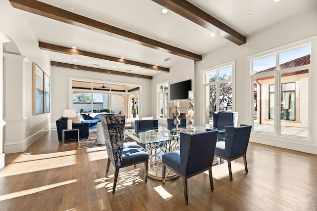 dining space with ornate columns, baseboards, beam ceiling, and hardwood / wood-style flooring