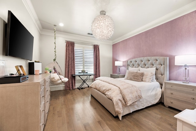 bedroom with a chandelier, ornamental molding, visible vents, and light wood-style floors