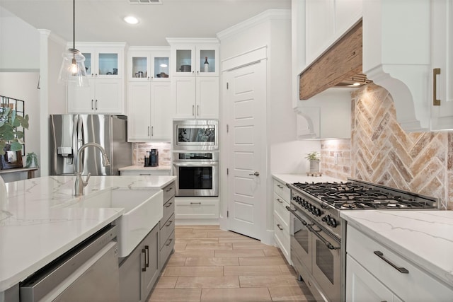 kitchen with hanging light fixtures, a sink, stainless steel appliances, recessed lighting, and white cabinetry