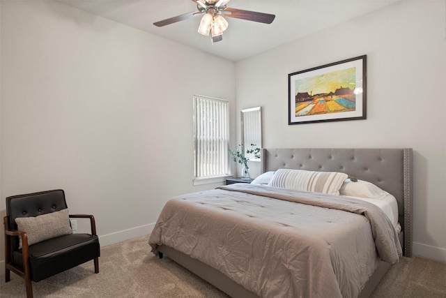 bedroom with a ceiling fan, baseboards, and light carpet