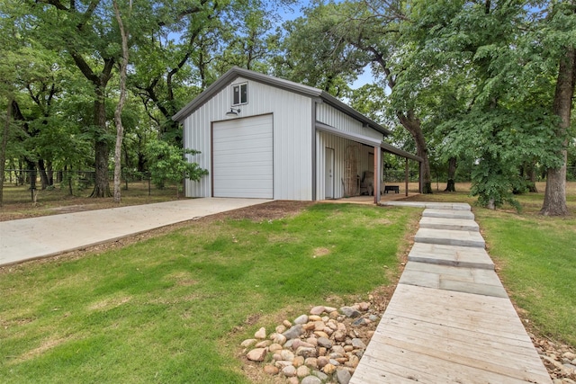 garage with fence, driveway, and a detached garage