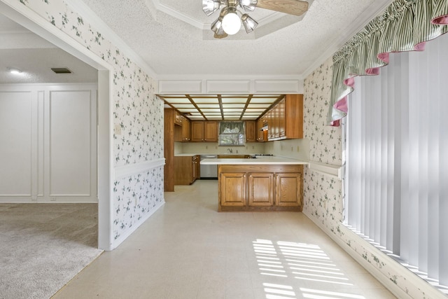 kitchen with stainless steel dishwasher, a textured ceiling, and wallpapered walls