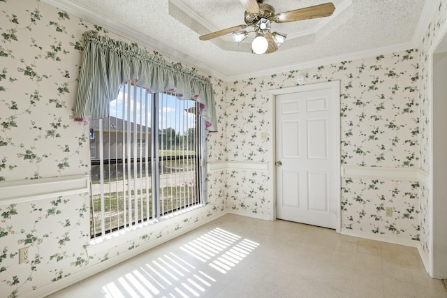 spare room featuring ornamental molding, a textured ceiling, a ceiling fan, and wallpapered walls