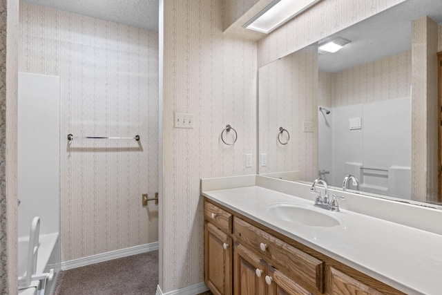 bathroom with vanity and wallpapered walls