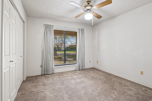 unfurnished bedroom with carpet flooring, a textured ceiling, and baseboards
