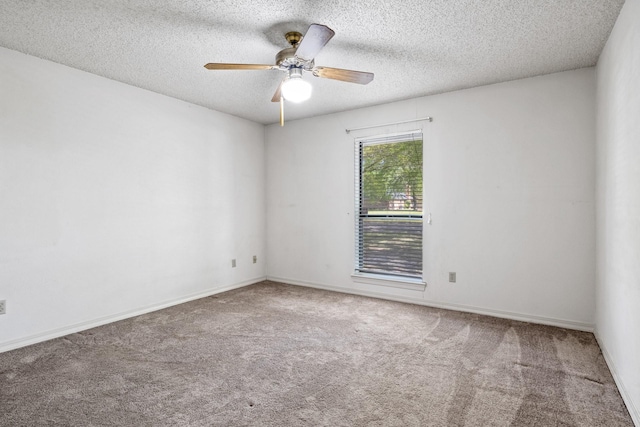 spare room featuring carpet floors, a ceiling fan, a textured ceiling, and baseboards