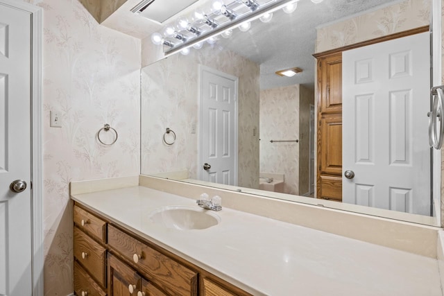 bathroom with vanity and wallpapered walls