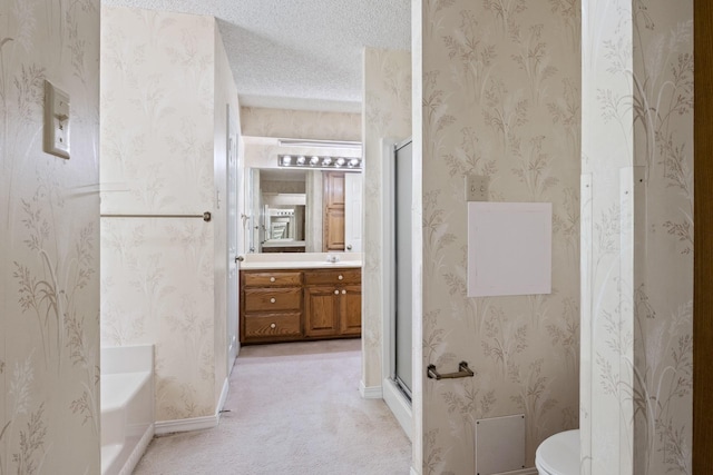 full bathroom with vanity, toilet, a textured ceiling, and a stall shower