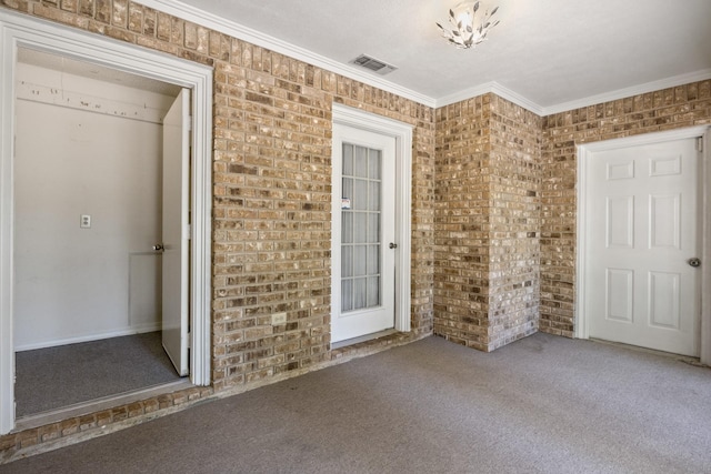 interior space featuring carpet floors, brick wall, visible vents, and ornamental molding