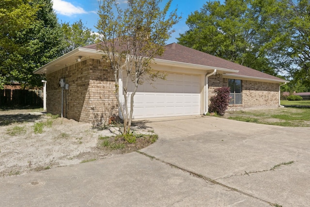 view of home's exterior featuring brick siding, an attached garage, and driveway