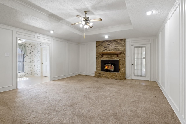 unfurnished living room featuring a textured ceiling, ceiling fan, carpet, and a decorative wall