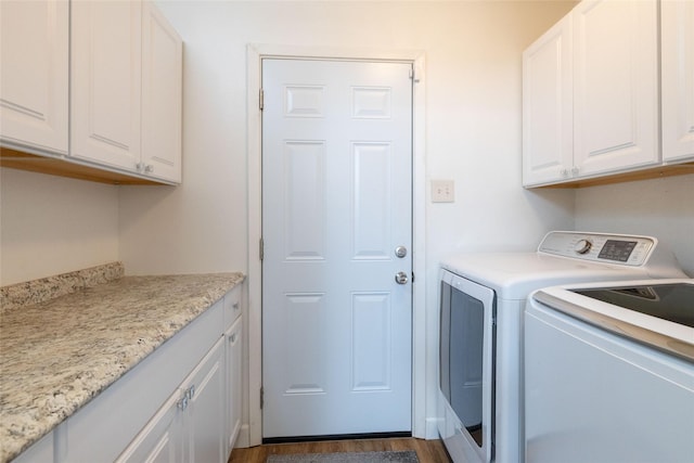 laundry room with independent washer and dryer, cabinet space, and dark wood-style floors