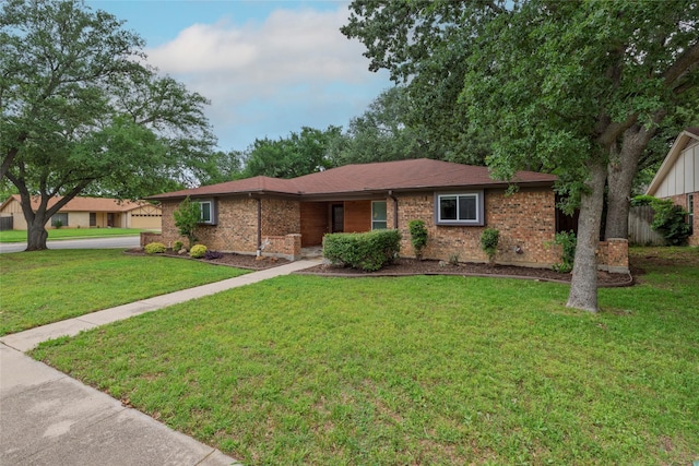 single story home with brick siding, fence, and a front yard