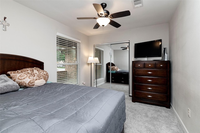 bedroom with light colored carpet, baseboards, visible vents, and a closet