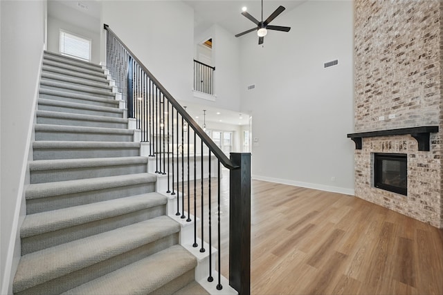 1851 Rosedale Ave, Van Alstyne, TX 75495 - stairs with wood finished floors, a healthy amount of sunlight, visible vents, a ceiling fan, and a high ceiling
