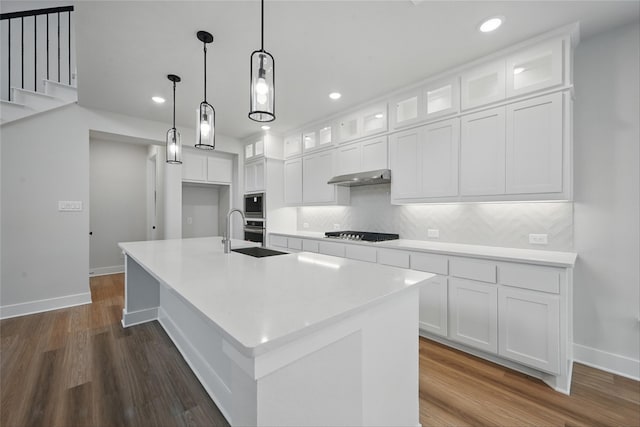 1851 Rosedale Ave, Van Alstyne, TX 75495 - kitchen featuring a sink, black stovetop, under cabinet range hood, tasteful backsplash, and dark wood-style floors