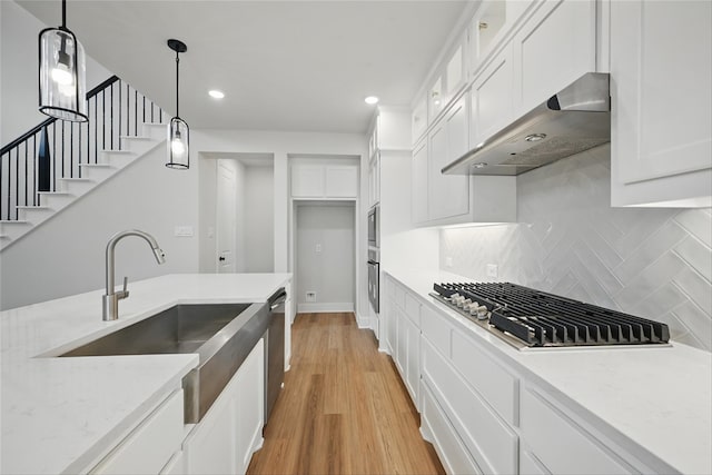 1851 Rosedale Ave, Van Alstyne, TX 75495 - kitchen featuring glass insert cabinets, stainless steel appliances, white cabinets, light wood-type flooring, and under cabinet range hood